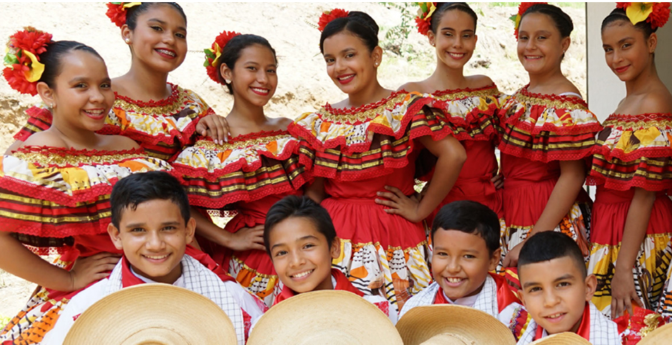 Grupo de estudiantes vestidos con trajes tradicionales posando juntos para una presentación cultural.
